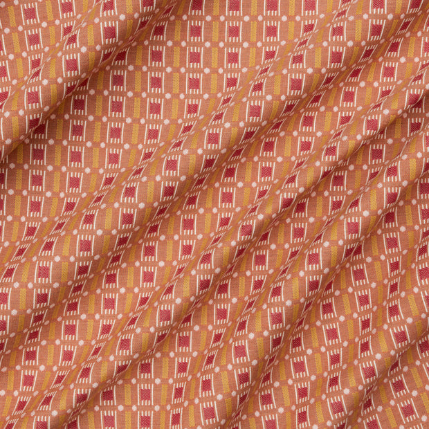 A yard of fabric featuring a geometric pattern with mustard yellow and pink colors.