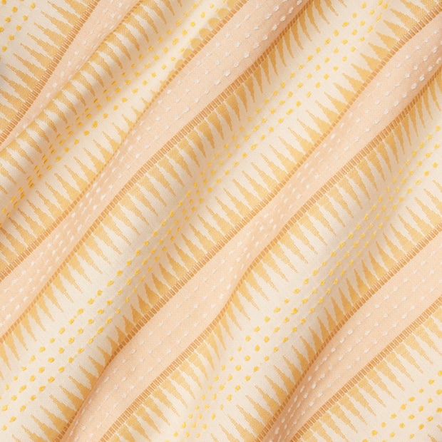 Close-up view of a fabric with a striped pattern in shades of yellow and pink.