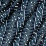 Close-up view of a fabric with a geometric pattern featuring stripes and dots in blue and white colors.