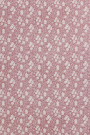 A roll of wallpaper with a floral pattern in pink and white colors. Calico Wallpaper – Burnt Rose | Burleigh x Barneby Gates