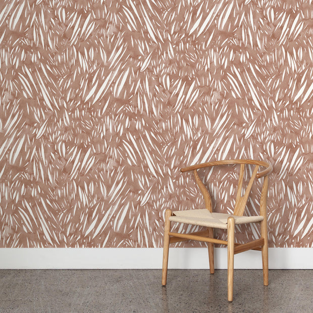 Wooden chair with beige cushion against a patterned wall.