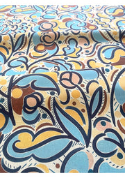 A fabric with a multicolored abstract pattern featuring various geometric and floral designs in shades of blue, maroon, orange, pink, and other colors.