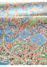 A fabric featuring a contemporary floral design with blue, green, and red colors on a patterned background.