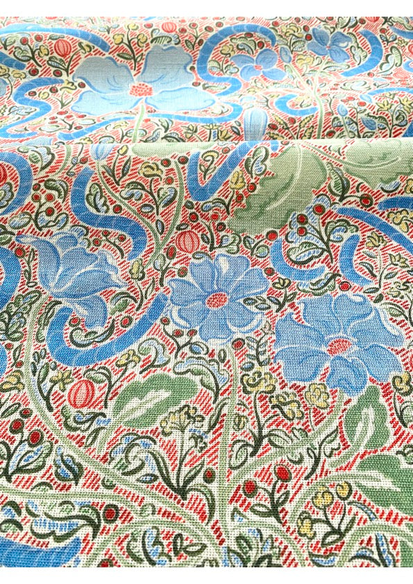 A fabric featuring a contemporary floral design with blue, green, and red colors on a patterned background.