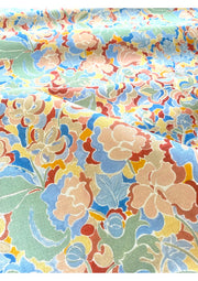 A fabric with a multicolored floral pattern featuring various colors such as beige, blue, green, pink, and yellow.