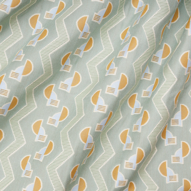 A close-up view of a fabric with a geometric pattern featuring stripes and shapes in blue, white, and yellow colors.