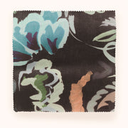 A yard of Bloomsbury Grande fabric with a floral pattern in blue, blush, brown, green, and pink colors on a black background.