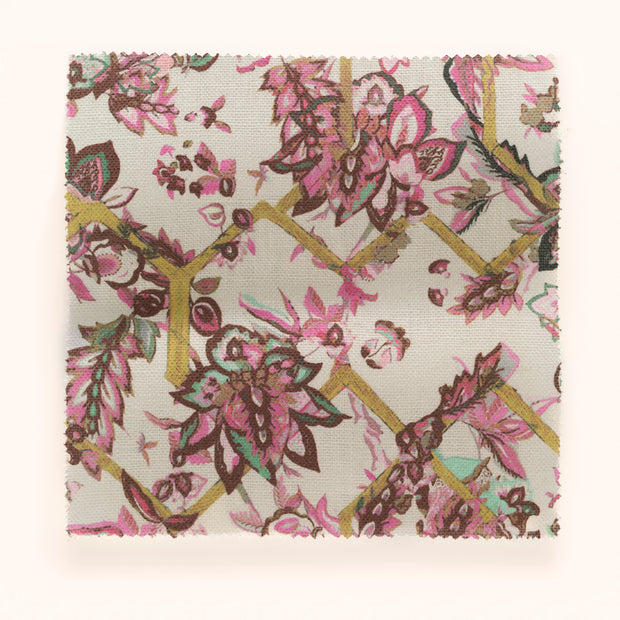 A piece of fabric with a floral pattern featuring pink, green, and yellow colors on a beige background.