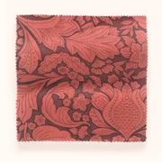 A swatch of red and brown floral patterned fabric.