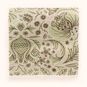 A piece of folk floral patterned fabric in various colors including brown, green, and pink.