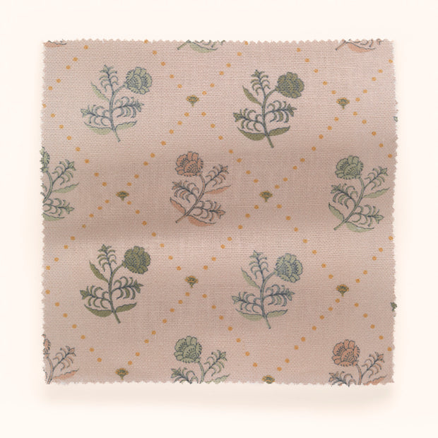 A swatch of floral patterned fabric in various colors including green, pink, and yellow on a beige background.