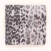 A piece of fabric with a leopard animal print pattern in shades of purple and pink.