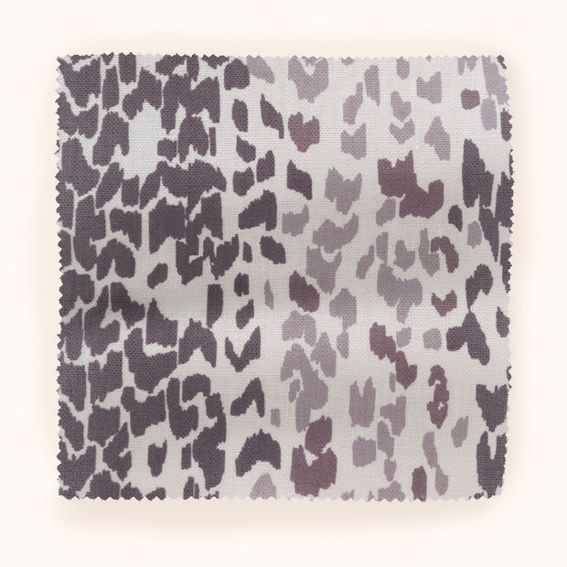 A piece of fabric with a leopard animal print pattern in shades of purple and pink.