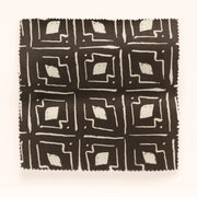 A yard of fabric with a geometric pattern consisting of beige and brown colors.