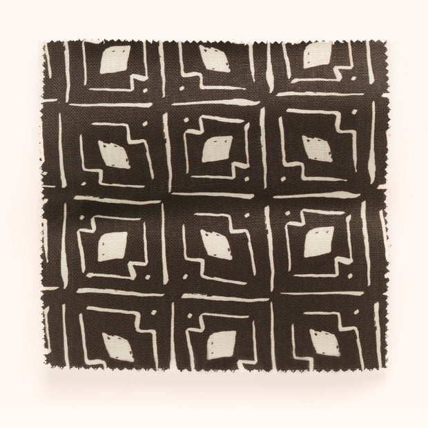 A yard of fabric with a geometric pattern consisting of beige and brown colors.