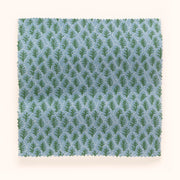 A yard of fabric with a blue and green microprint of tree patterns.