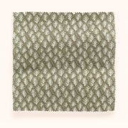 A swatch of pistachio-colored fabric with a tree pattern.