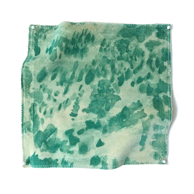 A swatch of green heather velvet fabric with a textured surface, featuring a pattern of varying shades of green.
