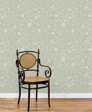 Vintage chair against a patterned wallpaper wall. Sage - Madras Floral Wallpaper by Panel