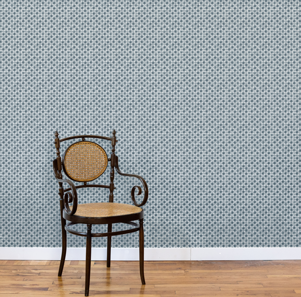 Vintage chair against a patterned wallpaper wall. Slate - Madras Geo Wallpaper by Panel