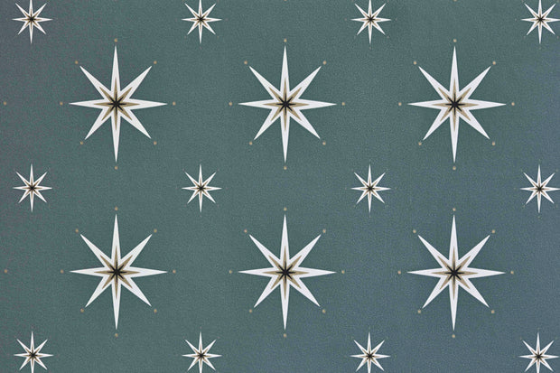 A section of wallpaper with a pattern of star-shaped designs in a dusky blue green color against a darker background - Dusky Blue Green Night Sky Wallpaper – Eco Non Woven Roll