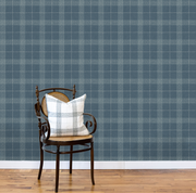 Chair with a plaid pillow against a blue checkered wall. Dark Slate - Prairie Style Plaid Wallpaper by Panel