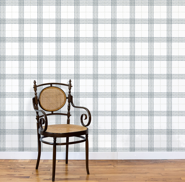 Wooden chair with a woven seat against a plaid wallpapered wall. Steelyard/Sage Wallpaper – Prairie Style Plaid | Modern Design