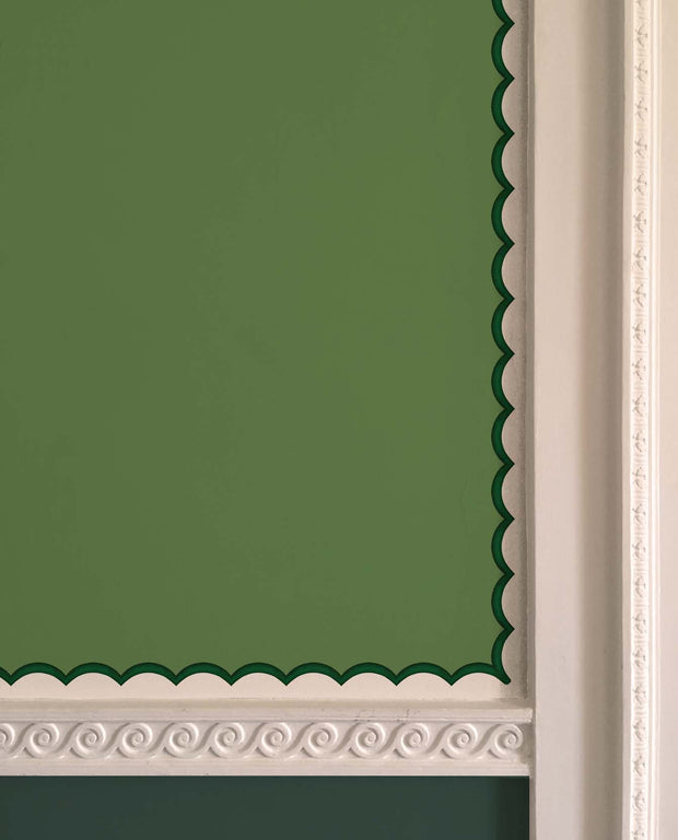 A section of dark green wallpaper with scalloped trim in a room, showing the detail of the scalloped edges - Emerald - Scalloped Wallpaper Border - Non Woven, 5cm Trim Width | Supply Showroom