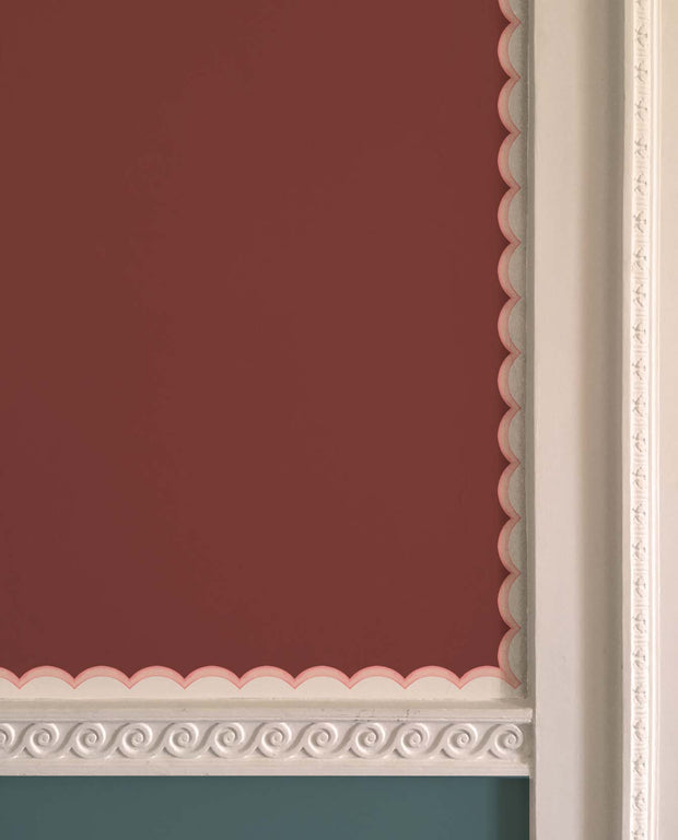 A scalloped pink wallpaper border with visible texture, installed on a wall with decorative molding - Pink - WP Scalloped Wallpaper Border, Non Woven, 10m Roll