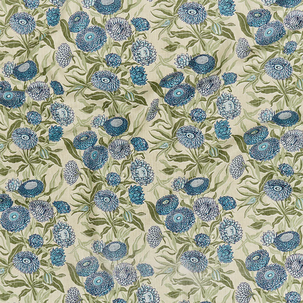 A piece of fabric featuring a floral pattern with blue flowers on a beige background.