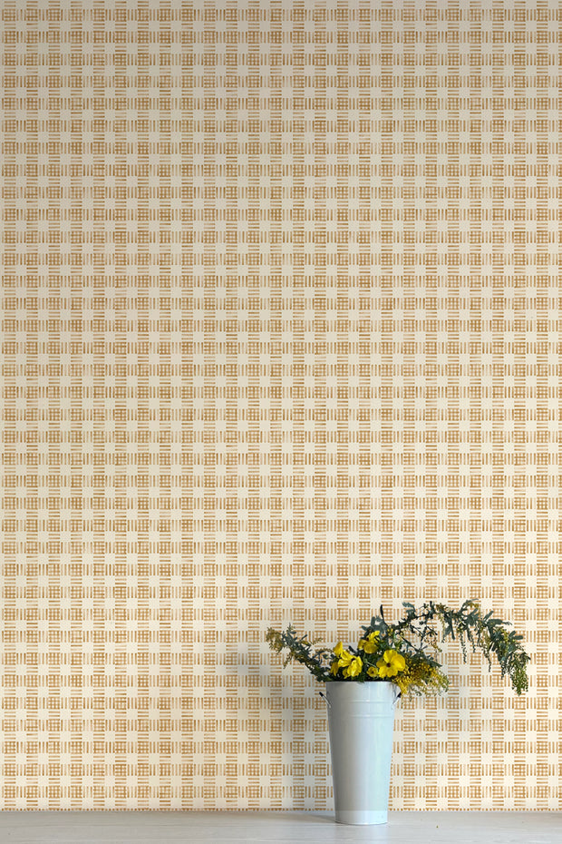 A wall adorned with a yellow and white checkered wallpaper, featuring a vase with flowers in the foreground.