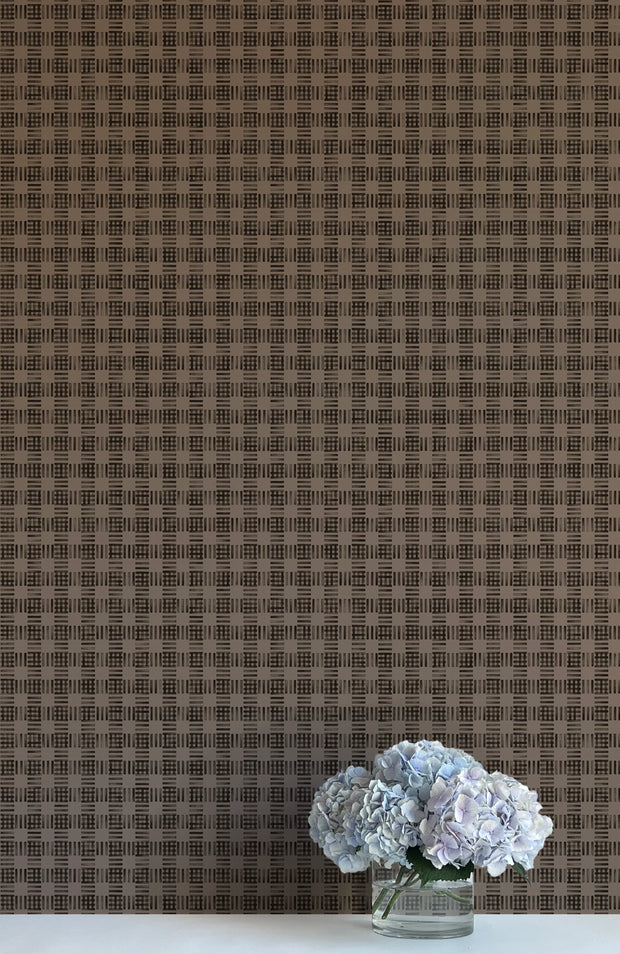 A close-up of a wallpaper with a brown and beige checkered pattern, featuring a vase with purple flowers to the bottom right.