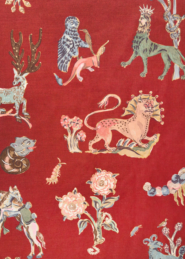 A piece of fabric with a red background featuring a bestiary pattern with various animals in a multicolor design.