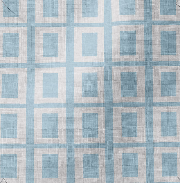 A textile fabric featuring a geometric pattern with blue and white squares on a light blue background.