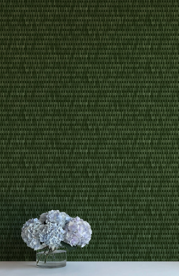 A wall adorned with dark green, solid-colored wallpaper and a vase containing purple flowers placed on a white surface - Patio Extra Olives Wallpaper – Playful Non-Woven Fruit Design