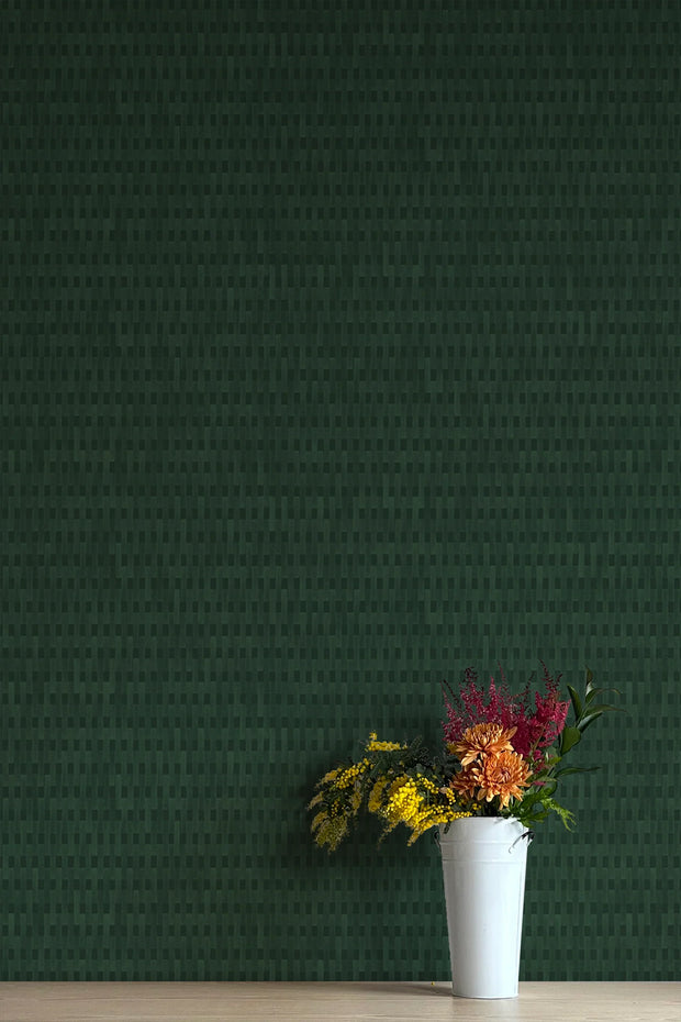 A section of dark green wallpaper with a pattern of vertical text stripes, flanked by two vases with flowers - Patio Nori Wallpaper – Modern Green Non-Woven Wallcovering