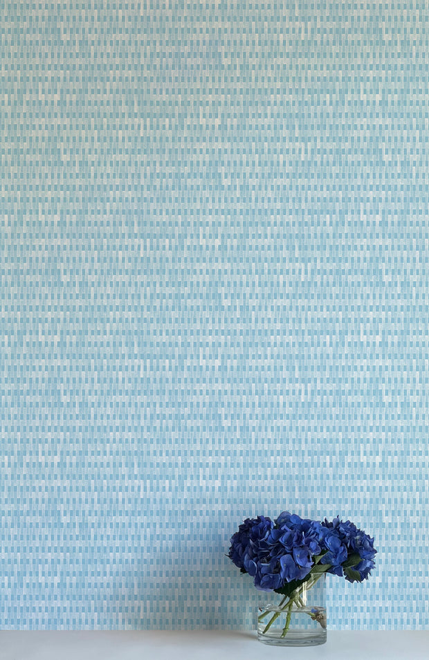 A wall adorned with blue multicolored stripes, floral patterned wallpaper, in a room with a vase containing blue flowers - Patio Robin Wallpaper – Modern Non-Woven Double Roll