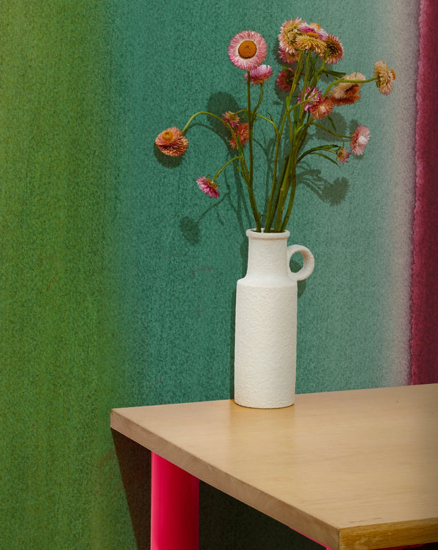 White vase with flowers on a wooden table against a colorful wall. Prism Wallpaper – Flood Mural | Custom Type II PVC Free