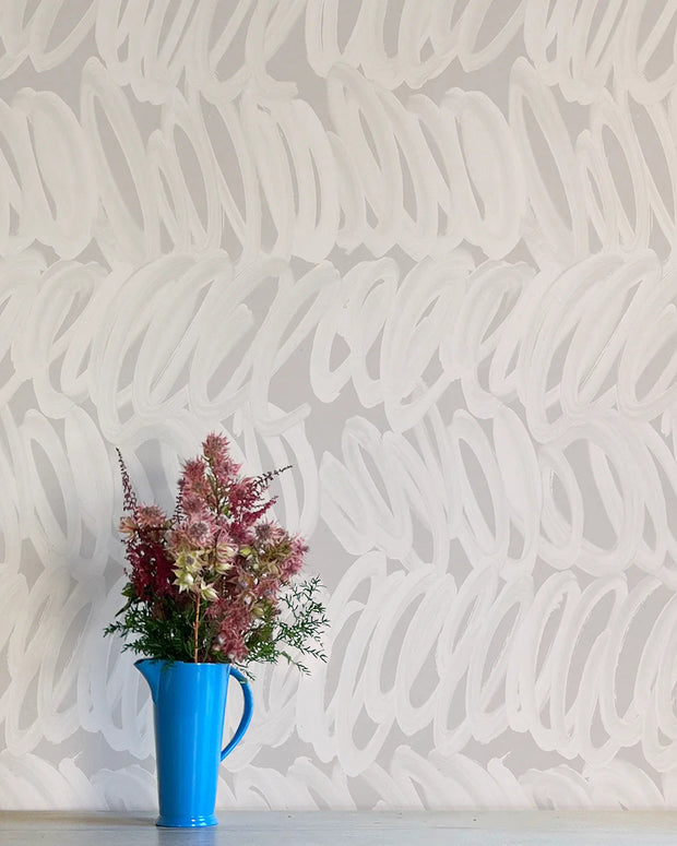 A wall adorned with white and gray geometric-patterned wallpaper, featuring a blue vase with pink and green flowers - Alto Wallpaper – Whisper Collection | Non-Woven