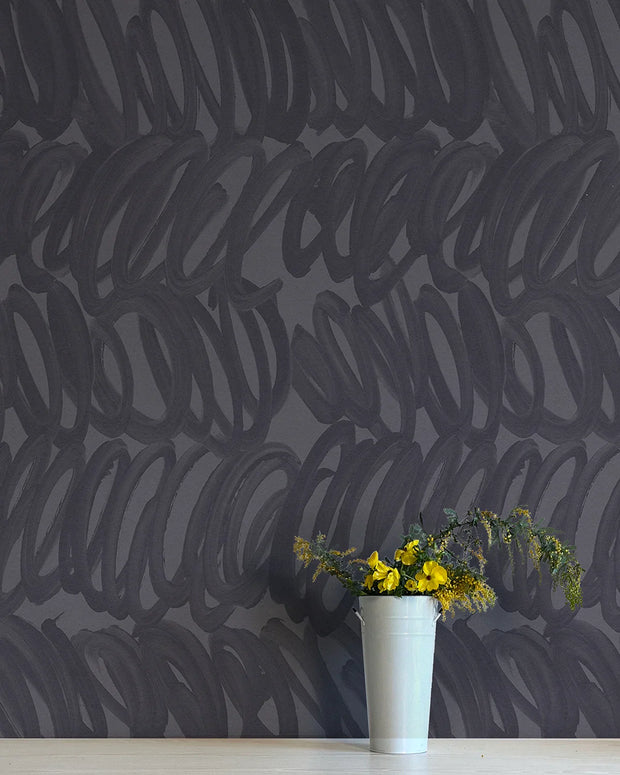 A section of wallpaper with a contemporary geometric pattern in shades of gray and blue, with a vase of yellow flowers in the foreground - Asea Wallpaper – Whisper Collection | Non-Woven