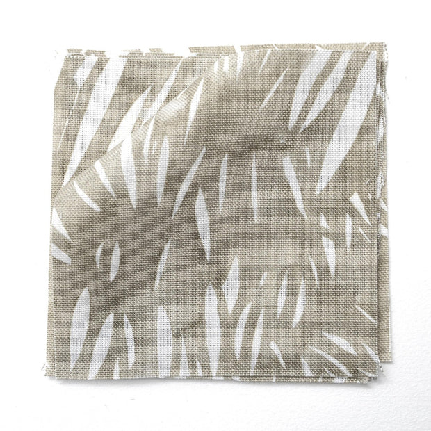 A yard of Windswept fabric with an abstract geometric pattern in beige, brown, gray, and white colors on a flat surface.