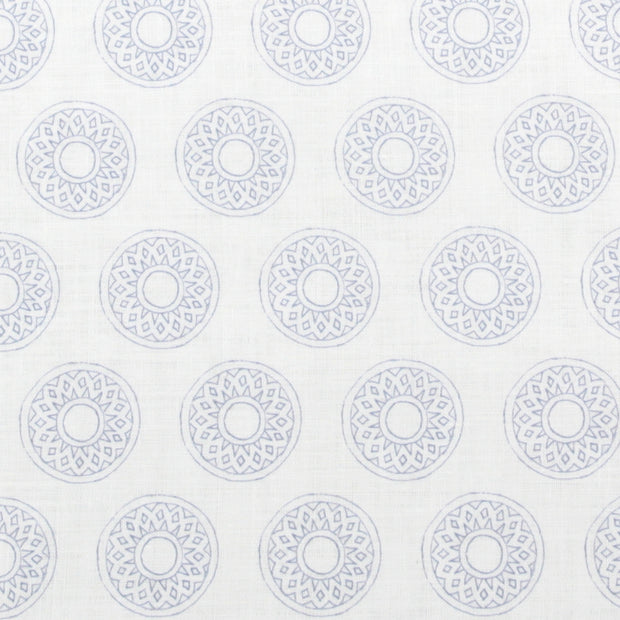 A fabric featuring a geometric pattern with circles in various shades of blue and purple on a white background.