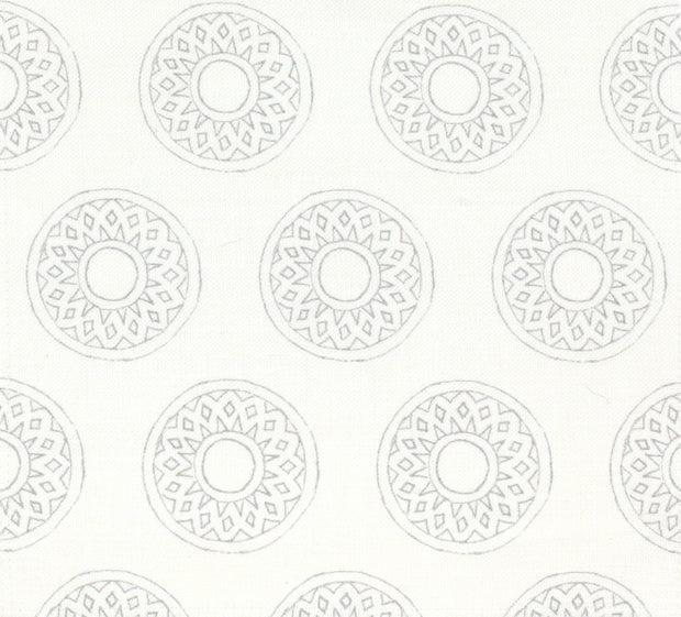 A fabric featuring a geometric pattern with interconnected circles in different shades of beige and white.